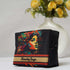 Black cosmetic bag with colorful design and 'Beauty Saga' branding in front of a vase with yellow flowers.