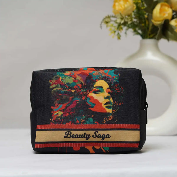 Black cosmetic bag with colorful design and 'Beauty Saga' branding on a white surface with a vase of yellow flowers in the background.