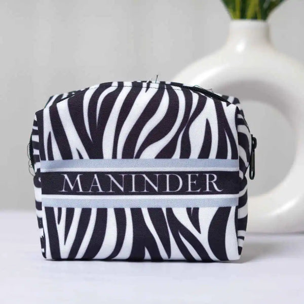 Zebra patterned pouch with 'MANINDER' branding on a white background
