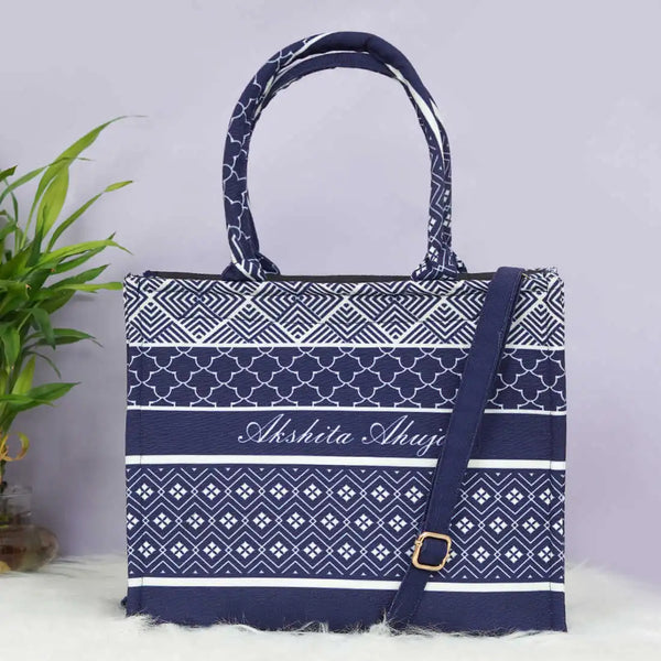 Navy blue and white patterned tote bag with a strap on a light gray background