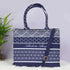 Navy blue and white patterned tote bag with a strap on a light gray background