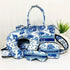 Blue and white travel set with a bag, eye mask, and pillow on a white background.